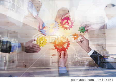Business team connect pieces of gears. Teamwork, partnership and integration concept. double exposure Business team connect pieces of gears. Teamwork, partnership and integration concept. double exposure 96123465