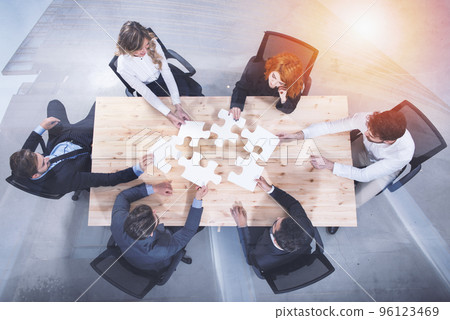 Teamwork of partners. Concept of integration and startup with puzzle pieces. double exposure Teamwork of partners. Concept of integration and startup with puzzle pieces. double exposure 96123469