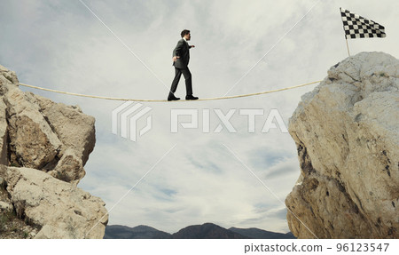 Business concept of businessman who overcome the problems reaching the flag on a rope 96123547