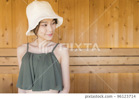 Sauna girl wearing a sauna hat and entering the sauna 96123714