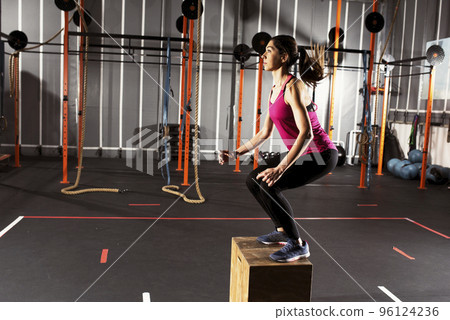 Athletic girl does box jump exercises at the gym Athletic girl does box jump exercises at the gym 96124236
