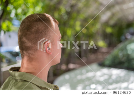 Close-up of a hearing aid on a man's ear. Close-up of a hearing aid on a man's ear. 96124620