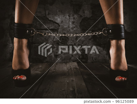 Sensual provocation of a sexy bdsm woman with chained legs 96125089