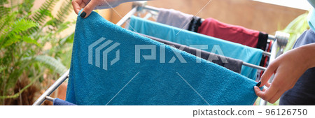 Housewife hanging clothes on dryer at home closeup 96126750