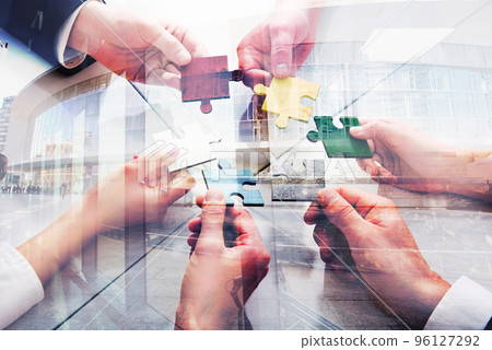 Teamwork of partners. Concept of integration and startup with puzzle pieces. double exposure Teamwork of partners. Concept of integration and startup with puzzle pieces. double exposure 96127292