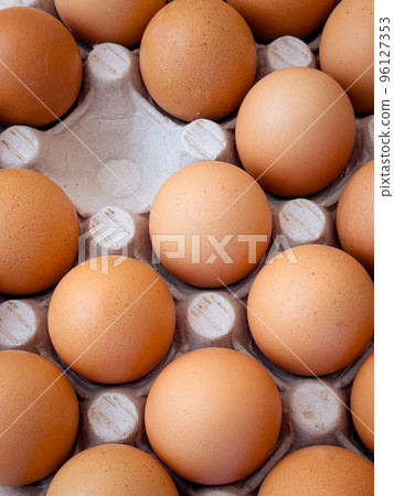 Brown eggs in cardboard egg box. Top view of raw organic chicken eggs in carton. Brown eggs in cardboard egg box. Top view of raw organic chicken eggs in carton. 96127353