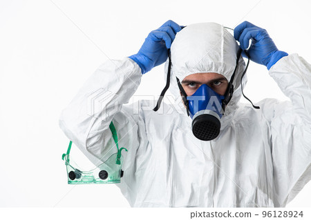 Doctor wearing protective biological suit and mask due to coronavirus 2019-nCoV global pandemic warning and danger background against white background. Doctor wearing protective biological suit and mask due to coronavirus 2019-nCoV global pandemic warning and danger background against white background. 96128924