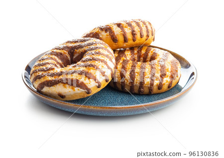 Donuts with chocolate and caramel icing isolated on white background. Donuts with chocolate and caramel icing isolated on white background. 96130836