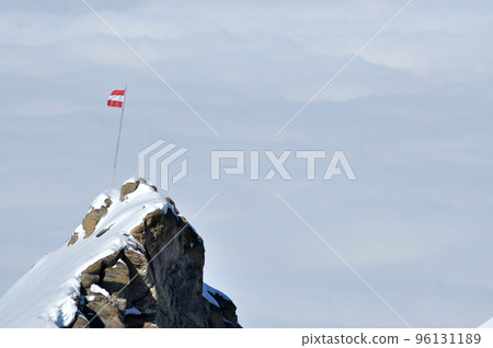 Rocky height in the Alps with the flag of Austria 96131189