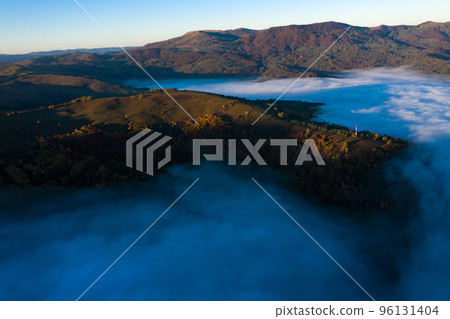 Aerial view of mist and clouds in the valley in sunrise Aerial view of mist and clouds in the valley in sunrise 96131404