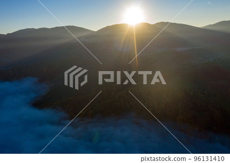Flying above the clouds in dawn. Misty morning in the valley, aerial  view 96131410