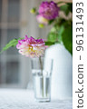 Variety of flowers in a vase on a wooden table in a vintage style room 96131493