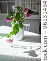 Variety of flowers in a vase on a wooden table in a vintage style room 96131494