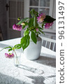 Variety of flowers in a vase on a wooden table in a vintage style room 96131497