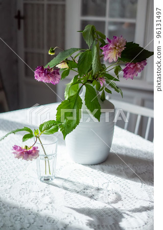 Variety of flowers in a vase on a wooden table in a vintage style room Variety of flowers in a vase on a wooden table in a vintage style room 96131497
