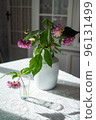 Variety of flowers in a vase on a wooden table in a vintage style room 96131499