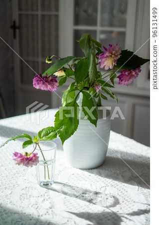 Variety of flowers in a vase on a wooden table in a vintage style room Variety of flowers in a vase on a wooden table in a vintage style room 96131499