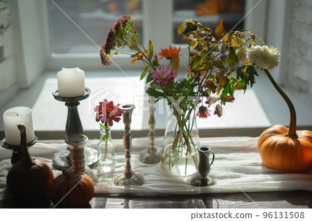 Variety of flowers in a vase on a wooden table in a vintage style room Variety of flowers in a vase on a wooden table in a vintage style room 96131508