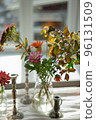 Variety of flowers in a vase on a wooden table in a vintage style room 96131509