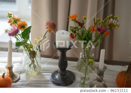 Variety of flowers in a vase on a wooden table in a vintage style room Variety of flowers in a vase on a wooden table in a vintage style room 96131511