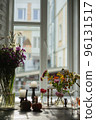 Variety of flowers in a vase on a wooden table in a vintage style room 96131517