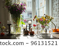 Variety of flowers in a vase on a wooden table in a vintage style room 96131521