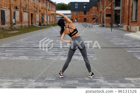 Woman is doing warm up exercising outdoor 96131526