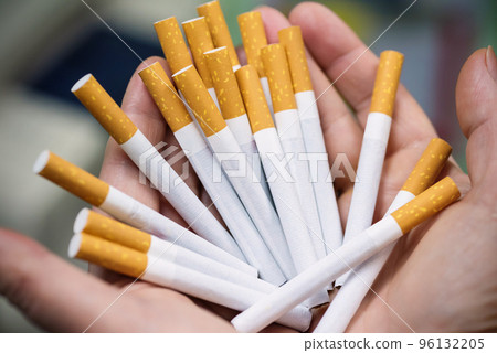A close-up of cigarettes on a girls palms. The fight with the addiction. A notion of health care 96132205