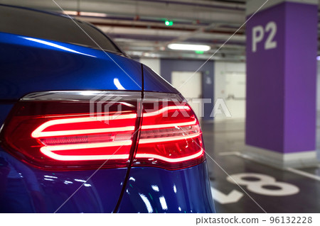 Car at underground parking, side rear view. Underground parking-garage. Closeup Car at underground parking, side rear view. Underground parking-garage. Closeup 96132228