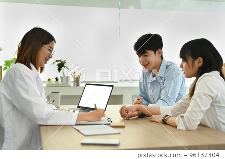 Gynecologist consultation with married couple for pregnancy planning during appointment at clinic. Family planning concept 96132304