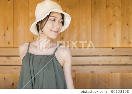 A young woman wearing a sauna hat and entering a sauna A young woman wearing a sauna hat and entering a sauna 96133108