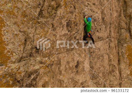 Man Climber Rock Climbing. Cliffs in Tamgaly Tas, Kazakhstan. Aerial View Man Climber Rock Climbing. Cliffs in Tamgaly Tas, Kazakhstan. Aerial View 96133172