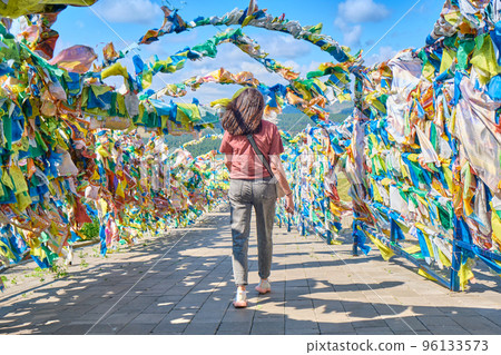 A girl walks under an arch with traditional Buddhist prayer flags in the Rinpoche Bagsha datsan in Ulan-Ude city of the Republic of Buryatia, Russia. A girl walks under an arch with traditional Buddhist prayer flags in the Rinpoche Bagsha datsan in Ulan-Ude city of the Republic of Buryatia, Russia. 96133573
