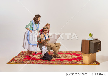 Portrait of young family spending time together in the living room isolated over grey background 96133672