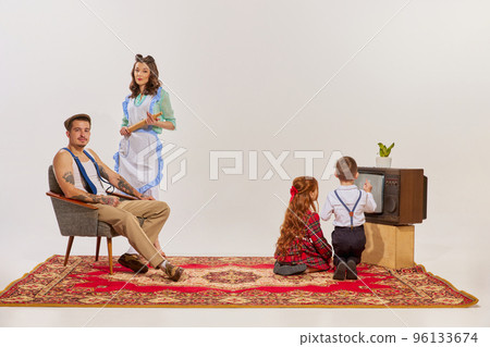Portrait of young family watching TV isolated over grey background. Kids watching cartoons. 96133674