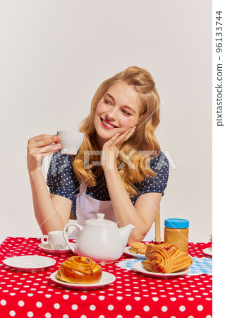 Portrait of lovely young woman having breakfast isolated over grey background. Calm morning 96133744