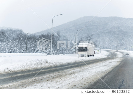 Big commercial semi-trailer truck trapped in snow drift on closed highway road at heavy snow storm blizzard cold winter day. Cargo vehicle stuck on freeway at bad weather conditions frosty snowfall Big commercial semi-trailer truck trapped in snow drift on closed highway road at heavy snow storm blizzard cold winter day. Cargo vehicle stuck on freeway at bad weather conditions frosty snowfall 96133822