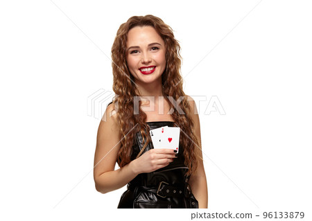 Pretty young redhead or brown-haired woman holding pair of aces in black leather dress isolated on white 96133879