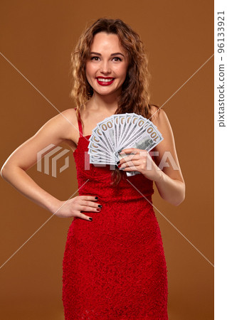 Image of lucky happy woman with brown long hair with fan of 100 dollar bills, lots of cash money, over brown background Image of lucky happy woman with brown long hair with fan of 100 dollar bills, lots of cash money, over brown background 96133921