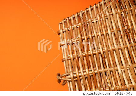 Wicker basket on orange background, space for text Wicker basket on orange background, space for text 96134743