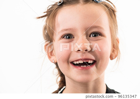 Portrait of a little girl on a white background with healthy, developing teeth Portrait of a little girl on a white background with healthy, developing teeth 96135347