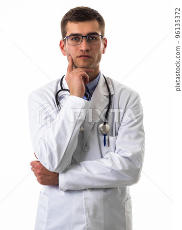 Portrait of hero in white coat. Cheerful smiling young doctor with stethoscope in medical hospital standing against white background. Coronavirus covid-19 danger alert 96135372
