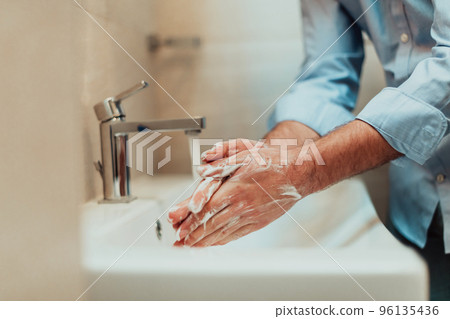 Man using soap and washing hands under the water tap. Hygiene concept hand closeup detail. Man using soap and washing hands under the water tap. Hygiene concept hand closeup detail. 96135436