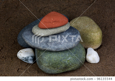 Assorted Pebbles and Stones Piled on a Wet Sandy Beach Assorted Pebbles and Stones Piled on a Wet Sandy Beach 96135544