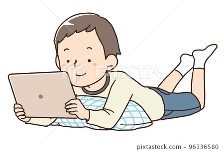一個男孩躺下看著平板電腦 一個男孩躺下看著平板電腦 96136580