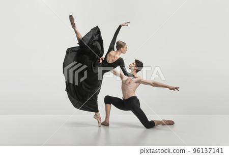 Young man and woman, ballet dancers performing isolated over grey studio background. Noble, pride dance Young man and woman, ballet dancers performing isolated over grey studio background. Noble, pride dance 96137141