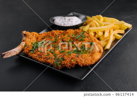 Fried wiener schnitzel from veal topside with french fries 96137414