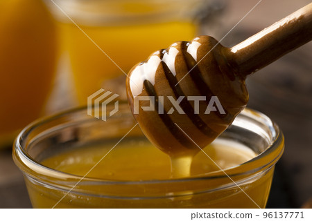 Honey on wooden honey-dipper closeup food background 96137771