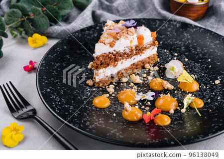 Carrot cake with walnuts on black plate 96138049
