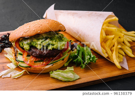 Burger with french fries on wooden tray 96138379